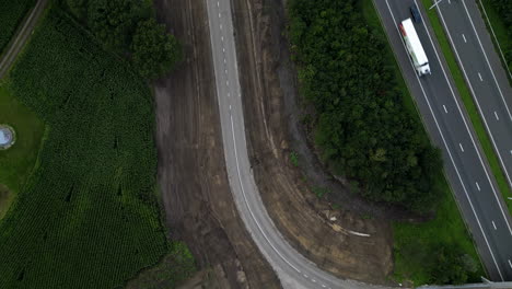 Freshly-built-new-road-near-highway,-aerial-top-down-view