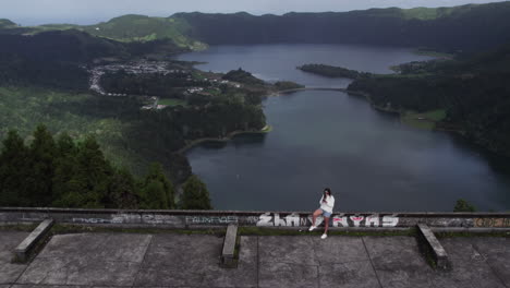 Girl-taking-selfie-atop-Monte-Palace-hotel,-overlooking-Azorean-lakeside