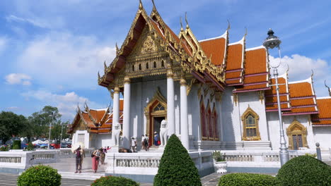 Thai-buddhist-temple-visited-by-people-on-a-hot-sunny-day-and-a-clear-blue-sky