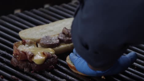A-chef-cooking-a-meat-sandwich,-a-meatloaf-with-melted-cheese,-and-a-hamburger-piece-of-bread-on-the-grill