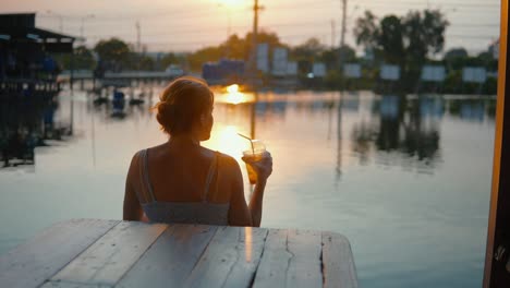 Young-Beautiful-Lady-Enjoying-A-Refreshing-Drink-At-Sunset