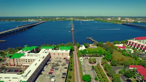 Aerial-view-of-Bradenton,-Florida-with-bridge-over-blue-river,-green-parks,-and-city