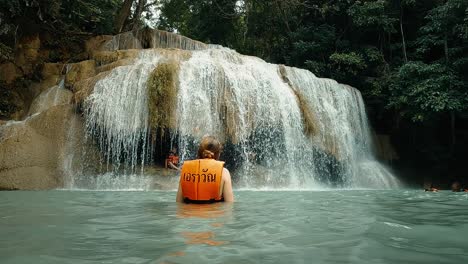 Person-swimming-in-waterfall-in-jungle