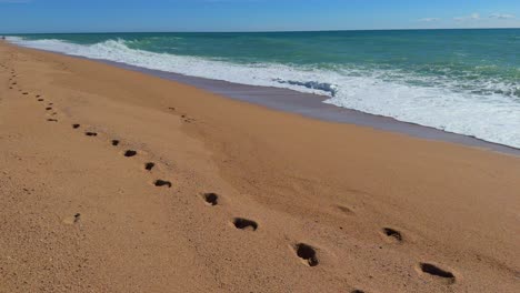 walking-on-the-beach,-footprints-in-the-sand-Mediterranean-sea,-turquoise-blue-Costa-Brava