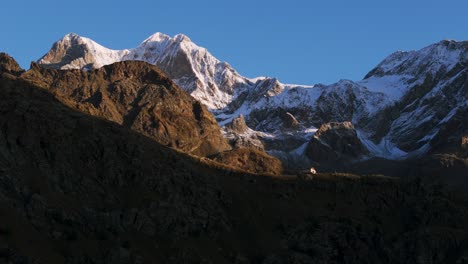Refugio-Alpino-Con-Montañas-Cima-Fontana-Al-Fondo,-Italia-Aérea-Ascendente