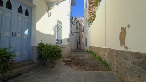 Walking-through-a-Mediterranean-town,-white,-blue-windows,-Ibizan-style