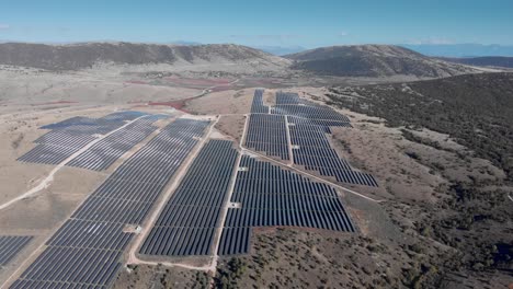 Drone-over-huge-photovoltaic-solar-power-park-row-panels-hills-dolly-shot-left