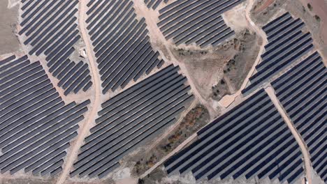 Drone-De-Arriba-Hacia-Abajo-Sobre-Paneles-De-Granja-De-Parque-De-Energía-Solar-Fotovoltaica-Día-Soleado-Rural