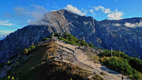 Toma-Panorámica-De-Derecha-A-Izquierda-Del-Nido-De-águila-Kehl-Steinhaus,-Berchtesgaden,-Alemania,-Con-Picos-Montañosos-Visibles-Y-Un-Tren-A-Pie-Con-Escaleras.