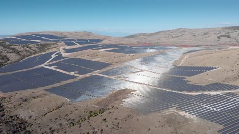 Aerial-drone-sunlight-reflects-on-big-photovoltaic-solar-park-farm-panels-sunny