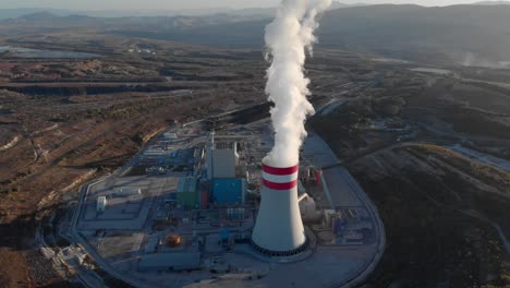Drone-steam-come-from-a-coal-fired-power-station-chimney-tilting-down-Sunset