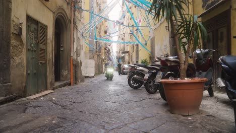 Motorradfahrt-Durch-Die-Engen-Straßen-Neapels,-Die-Mit-Fußball-Attributen-Geschmückt-Sind