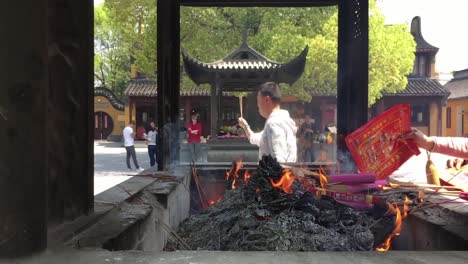 Menschen-Entsorgen-Papiere,-Räucherstäbchen-Und-Kerzen-Im-Longhua-Tempel-In-Shanghai,-China