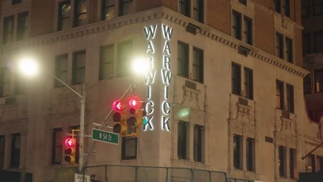 Warwick-hotel-sign-on-corner-of-building-54th-street,-illuminated-at-night