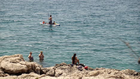 Holiday-makers-on-paddle-board-and-swimming-at-Beach-Njive