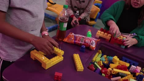 close-up-shot-of-kids-playing-with-lego-bricks-building-models
