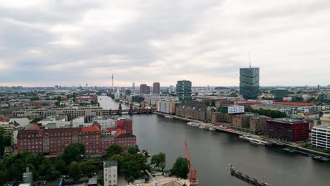 Erleben-Sie-Den-Zauber-Der-Berliner-Skyline-Und-Der-Berühmten-Oberbaumbrücke-Aus-Der-Vogelperspektive,-Während-Eine-Drohne-Anmutig-über-Die-Spree-Gleitet