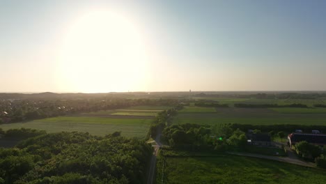 Aerial-View-of-Sunset-over-Green-Agricultural-Fields-of-Zeeland,-Netherlands