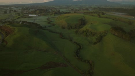 Above-lush-green-meadow-with-revealing-view-of-Mount-Taranaki,-New-Zealand