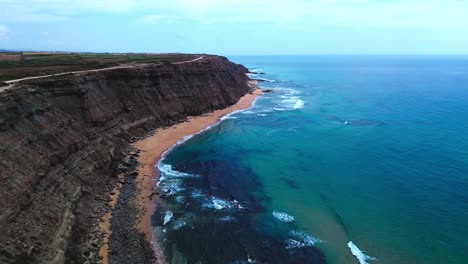 aerial-view-of-ocean,-crushing-waves-and-steep-black-cliffs,-4k