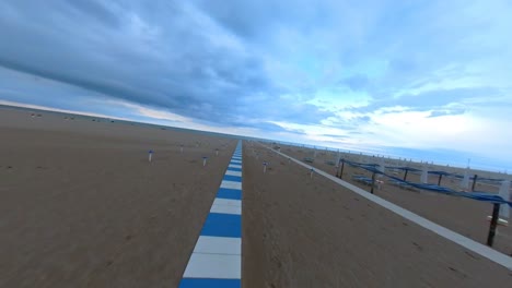 White-and-Blue-Tiled-Pathway-Leading-to-the-Sea-across-the-Beach-in-Rimini,-Italy