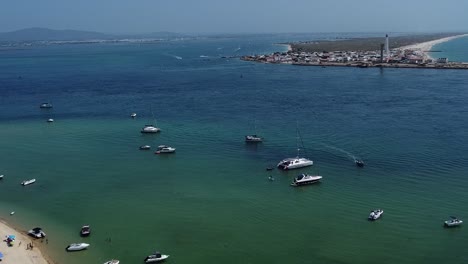 Wasserkanal-Zwischen-Leuchtturminsel-Und-Einsamer-Insel-Mit-Ausflugsbooten-Auf-Smaragdgrünem-Wasser,-Algarve