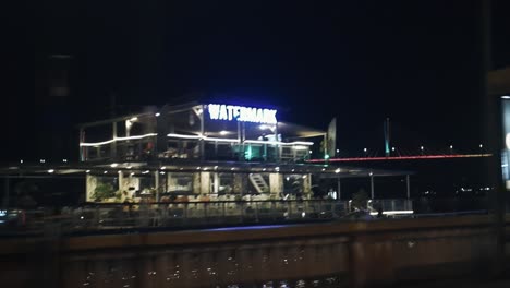 Beliebtes-Schwimmendes-Restaurant-Wasserzeichen,-Das-Gäste-Mit-Blauem-Neon-Zum-Essen-Lockt