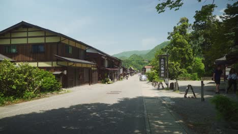 Blick-Auf-Die-Straße-In-Shirakawago-Mit-Waldhanglandschaft-Im-Hintergrund