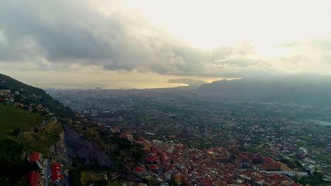 Aerial-drone-shot-of-Palermo-city-on-the-foothills-surrounded-by-mountains-along-with-Mediterranean-sea-coast-in-Sicily,-Italy-on-a-cloudy-day