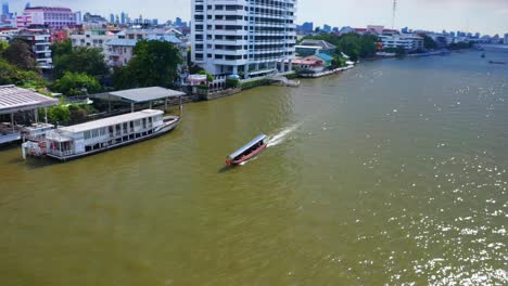 Traditional-Tourist-Boat-Sailing-Across-Chao-Phraya-River-In-Bangkok-City,-Thailand