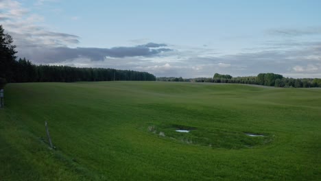 Grünes-Feld-Bei-Sonnenuntergang-In-Ermland,-Polen---Drohnenaufnahme-Aus-Der-Luft