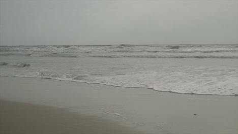 Cinematic-shot-of-waves-on-a-sandy-beach-in-India,-Goa,-Slomo