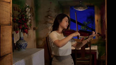 Female-musician-playing-melodic-tunes-on-violin-in-ambient-homely-setup