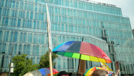 March-of-freedom-in-defence-of-democracy-in-Warsaw-With-People-Banner-And-Rainbow-Coloured-Umbrellas-Past-Office-Building