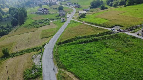 Aerial-view-of-desolate-roads-surrounded-by-green-meadows-in-the-rural-region-of-the-Cotian-Alps,-on-the-border-of-Italy-and-France