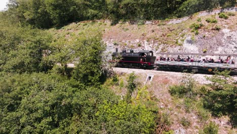 Drone-tracking-of-a-steam-train-on-the-edge-of-a-cliff,-Martel,-Lot,-France