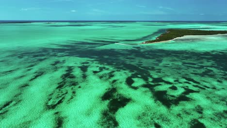 Wide-Aerial-View-of-Bahamas-Flat,-Island,-and-Boat-Motoring-Away
