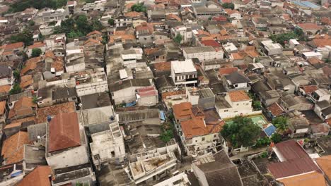 Luftaufnahme-Von-Oben-Nach-Unten-Eines-überfüllten-Indonesischen-Slums-Mit-Amateurfußballplatz-An-Einem-Sonnigen-Tag---Jakarta,-Indonesien