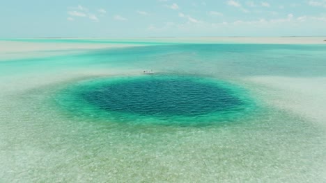 Aerial-View-Approaching-Bahamas-Blue-Hole-with-Fishing-Boat-At-Edge
