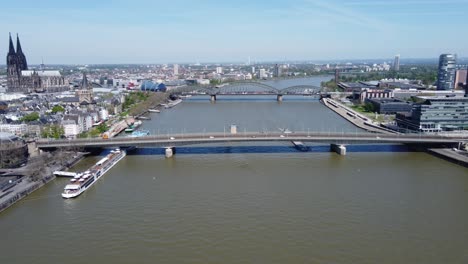 Aerial-dolly-push-in-above-bridges-crossing-river-in-cologne-germany