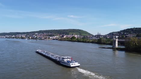Cargo-ferry-barge-travels-upstream-exploring-with-commuters-Bingen,-aerial-tracking