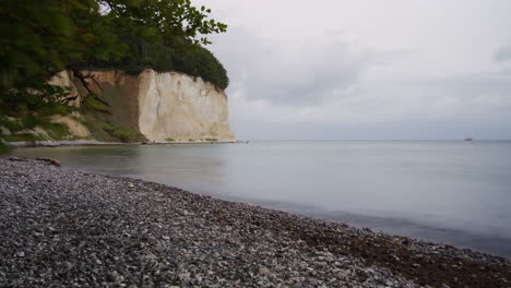 Timelapse-of-Clouds-Movement-Over-White-Chalk-Cliffs-on-Ruegen-Island,-Pebble-Beach-And-Low-TIde