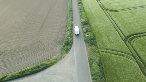 Delivery-Van-On-The-Way-To-Deliver-Parcel-Driving-In-The-Narrow-Irish-Road-Along-The-Wheat-Fields