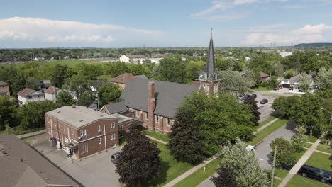 Drone-descend-tilt-up-along-side-of-st-catharines-church-on-beautiful-blue-sky-day