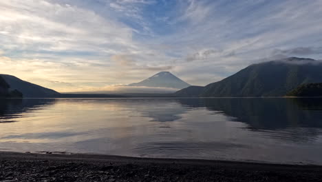 A-mesmerizing-time-lapse-as-Lake-Motosu-awakens,-bathed-in-the-ethereal-hues-of-first-light,-with-Fuji-san's-majesty-as-the-centerpiece