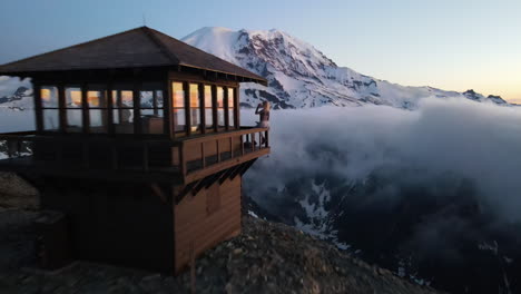 Beautiful-blonde-girl-with-smile-on-her-face-standing-on-the-Mount-Fremont-Fire-Lookout-and-watching-Mount-Rainier-at-sunset