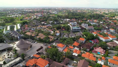 Vuelo-Aéreo-Sobre-El-Distrito-De-Berawa,-Zona-Residencial-De-Bali,-Villas-De-Alquiler-Y-Edificios-Hoteleros-Con-Techos-Naranjas