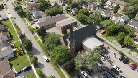 Aerial-push-in-tilt-down-above-st-catharines-church-steeple-and-grey-roof-top-covering