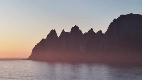 Silhouettierte-Insel-Und-Ruhiges-Meer-Bei-Sonnenaufgang-In-Senja,-Norwegen