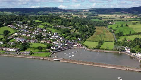 Aerial-drone-shot,-moving-from-right-to-left-showing-the-village-of-Cockwood-and-the-harbour-on-the-Exe-estuary-in-Devon,-UK